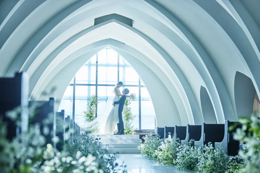 純白のチャペルの祭壇に立つ新郎新婦